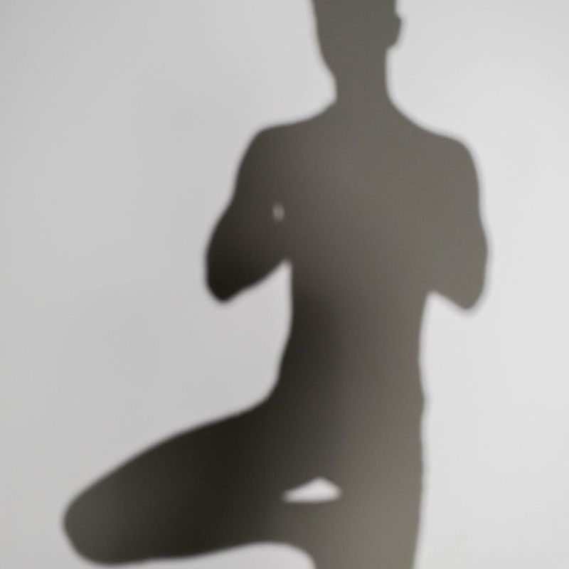 Silhouette of a person meditating against a calm, abstract background.